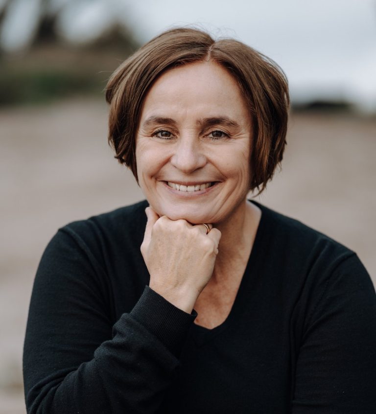 Portrait von Nicole Breuer, systematische Supervisorin in Köln, nachdenklich mit Hand am Kinn